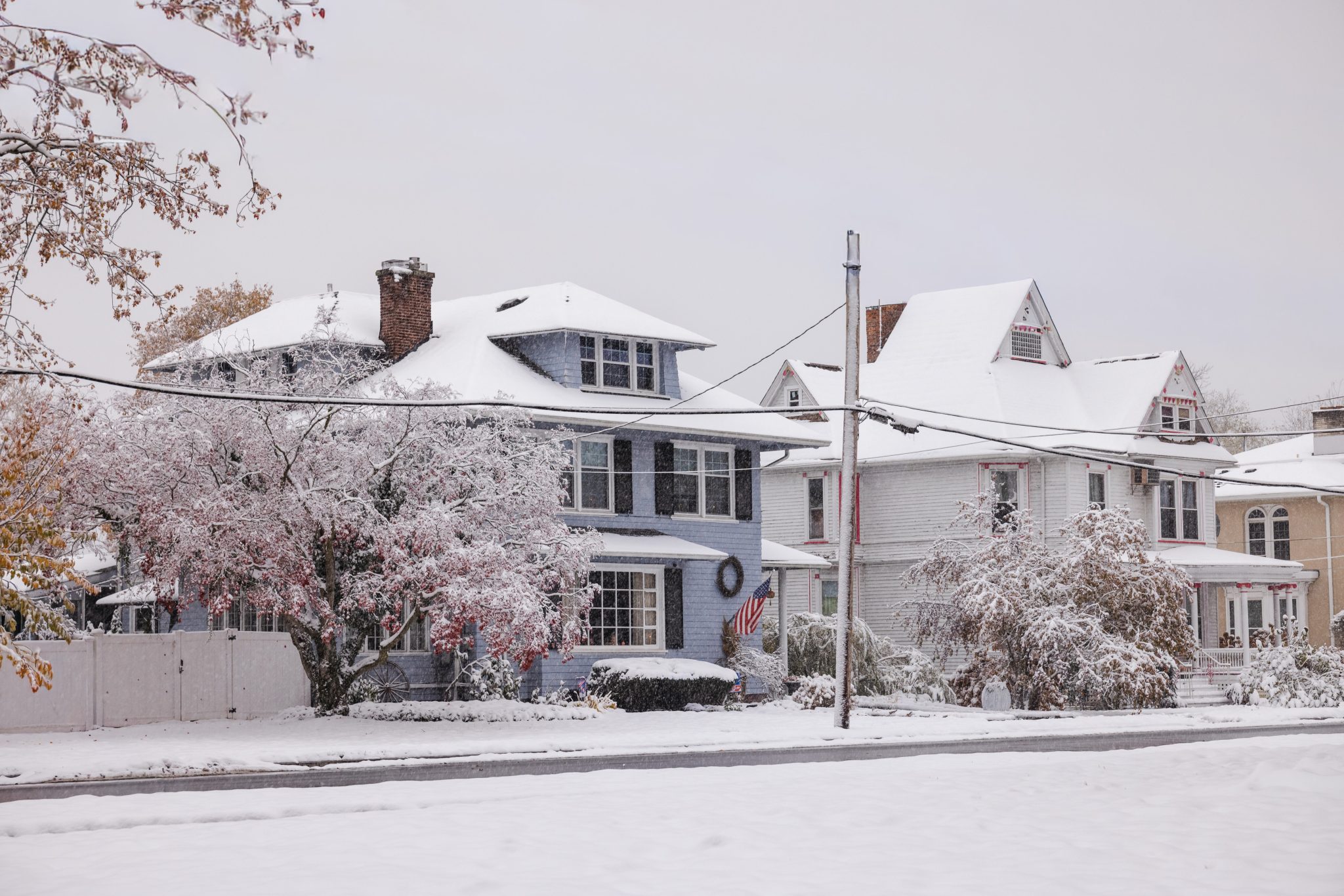 Snow covered homes in a residential neighborhood during winter weather, highlighting conditions that can impact military and veteran families